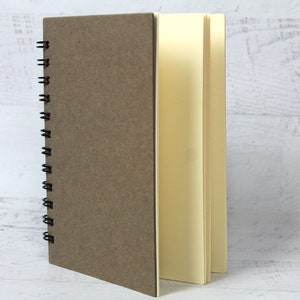 May include: A brown spiral bound notebook with blank cream colored pages.