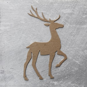 May include: A brown paper cutout of a deer with antlers standing on a gray textured background.