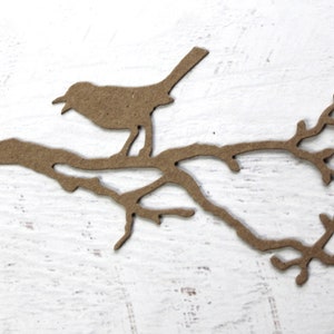 May include: A brown paper silhouette of a bird perched on a branch with leaves.