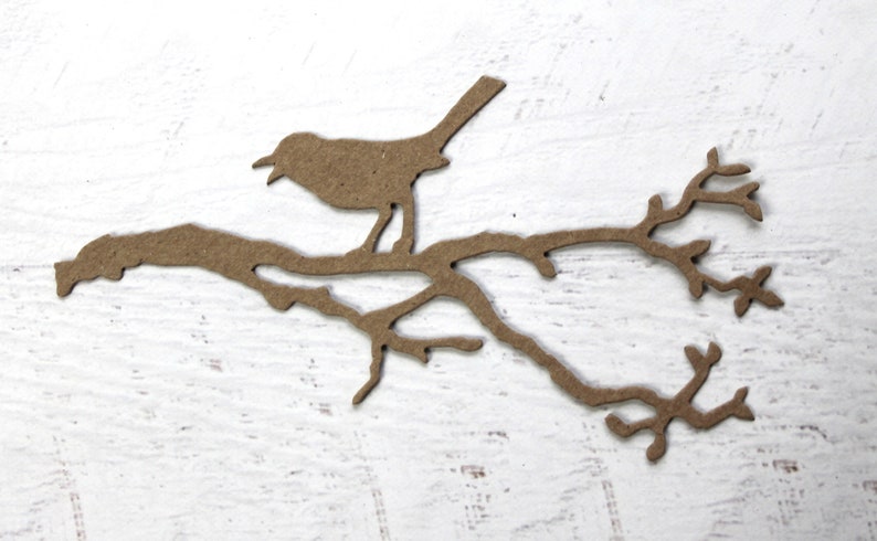 May include: A brown paper silhouette of a bird perched on a branch with leaves.