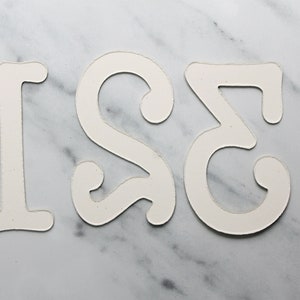 May include: White paper cut-out numbers 1, 2, and 3 on a marble background.