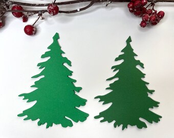 May include: Two green paper Christmas tree cutouts on a white background.