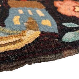 Pu&ograve; includere: Primo piano di un tappeto colorato tessuto a mano con uno sfondo marrone scuro. Il tappeto presenta una variet&agrave; di forme e motivi in ​​tinte di blu, giallo, marrone e rosa.
