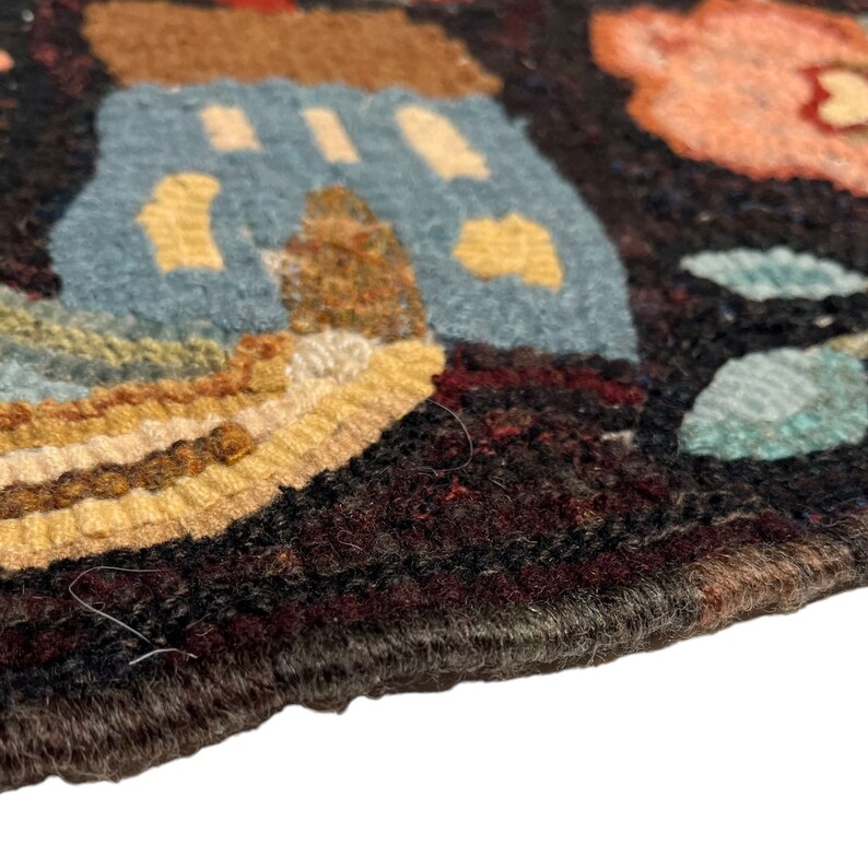 Pu&ograve; includere: Primo piano di un tappeto colorato tessuto a mano con uno sfondo marrone scuro. Il tappeto presenta una variet&agrave; di forme e motivi in ​​tinte di blu, giallo, marrone e rosa.