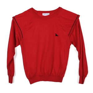 May include: Red long-sleeve sweatshirt with black trim on the shoulders and cuffs. A small black horse logo is embroidered on the front. The label reads "Little Girl".