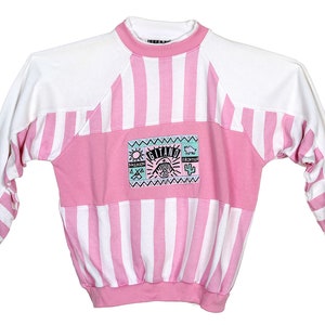 May include: Pink and white striped sweatshirt with a colorful graphic patch that says "Gitano" on the front.