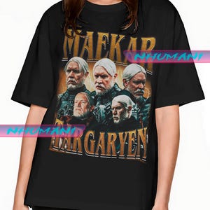 Könnte beinhalten: Schwarzes T-Shirt mit einem Grafikdesign im Vintage-Stil. Der Text "MAEKAR TARGARYEN" ist in Gold gehalten, mit Porträts mehrerer Männer mit weißen Haaren und Bärten auf gelbem Hintergrund.