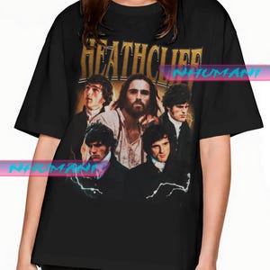 May include: Black t-shirt featuring a vintage-style graphic of a group of men with the text "HEATHCLIFF" in gold lettering. The graphic has a distressed look, giving it a retro aesthetic. The shirt is a classic crew neck.