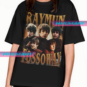 Könnte beinhalten: Schwarzes T-Shirt mit einem Vintage-Grafikdesign, das eine Gruppe von Personen und den goldenen Text "RAYMUN FOSSOWAY" zeigt. Die Grafik hat einen verblassten, abgenutzten Look.
