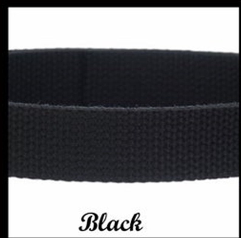May include: A solid black woven fabric strap with a distinct textured surface. The material appears to be a durable webbing, featuring a consistent tight weave pattern throughout the entire length of the band. The word Black is printed below.