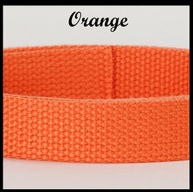May include: A bright orange woven fabric strap with a distinct textured grid pattern. The word Orange is printed in a black cursive script font above the strap, which is positioned horizontally across the center of the frame.