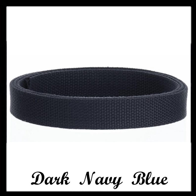 May include: A dark navy blue belt made of a woven fabric material. The belt is coiled into a circular shape, displaying a consistent textured pattern across its entire surface. The text "Dark Navy Blue" is printed in black below the belt.