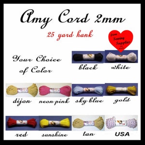 May include: Amy Cord 2mm 25 yard hank in various colors including black, white, dijon, neon pink, sky blue, gold, red, sunshine, tan, and a USA flag pattern. Each cord is wrapped with a label and presented as a collection of individual hanks.