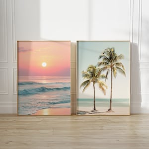 Könnte beinhalten: Zwei gerahmte Drucke von Strandszenen. Der erste Druck zeigt einen rosa und orangefarbenen Sonnenuntergang über einem blauen Meer mit Wellen. Der zweite Druck zeigt zwei Palmen an einem Strand mit blauem Wasser und einem hellblauen Himmel.