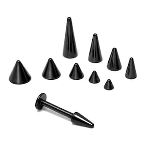 Puede incluir: Una colección de joyas corporales negras en forma de cono, que incluyen tachuelas y un labret. Las piezas varían en tamaño, con diferentes alturas. Las joyas se exhiben sobre un fondo blanco, resaltando el acabado brillante del metal.