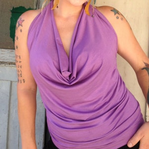 May include: A purple halter top with a cowl neck. The top is made of a soft, stretchy fabric and has a relaxed fit.