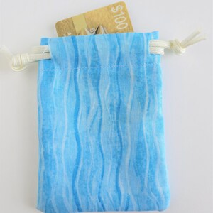 May include: A small blue drawstring bag with a white and blue wavy pattern. A gift card with the text "$100" is inside the bag.