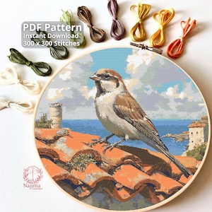 May include: A cross-stitch pattern featuring a detailed image of a sparrow perched on a terracotta tile roof, with a coastal background. The design is framed in a wooden hoop, with embroidery floss in various colors. Text reads "PDF Pattern Instant Download 300 x 300 Stitches."