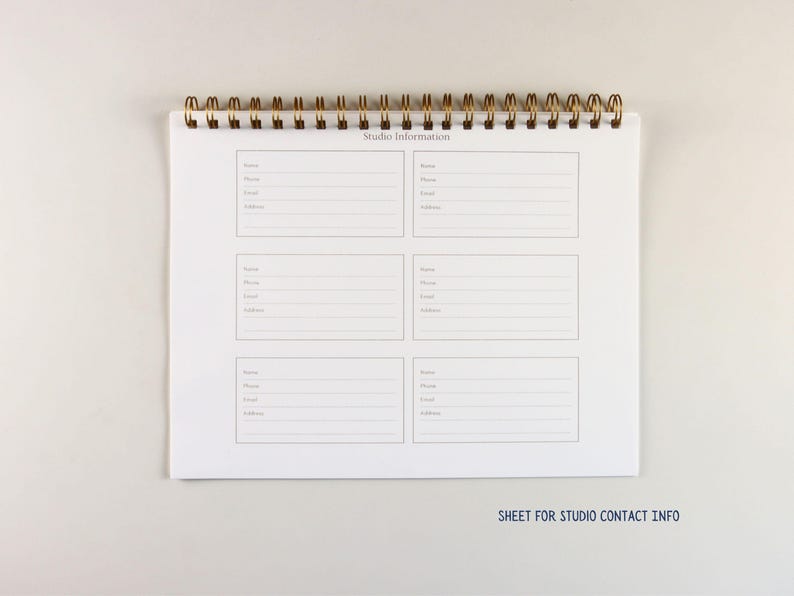 May include: A white spiral-bound notebook with gold-colored metal rings. The notebook pages are printed with lined sections for contact information, including name, phone, email, and address. The text "Studio Informations" is printed at the top.