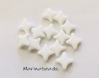 May include: A group of white star-shaped beads. The beads are made of glass and have a smooth, polished finish.