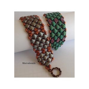 May include: Two beaded bracelets, one in shades of gray and copper, the other in green and pink, with a copper clasp. The bracelets are on a white surface with the text "Marinabeads" in the lower left corner.