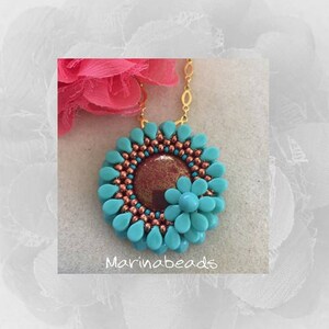 May include: A turquoise and copper beaded necklace with a flower pendant. The pendant has a copper centre and turquoise petals. The necklace is on a gold chain. The text "Marinabeads" is visible below the pendant.