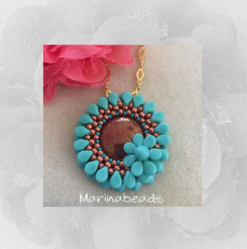 May include: A turquoise and copper beaded necklace with a flower pendant. The pendant has a copper centre and turquoise petals. The necklace is on a gold chain. The text "Marinabeads" is visible below the pendant.