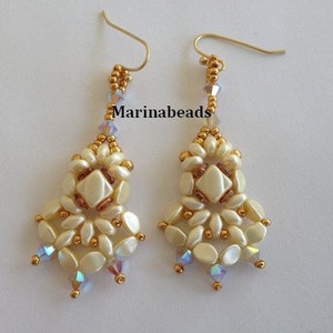 May include: A pair of white and gold beaded earrings with a geometric design. The earrings are made with small, round beads and have a dangling, teardrop shape.