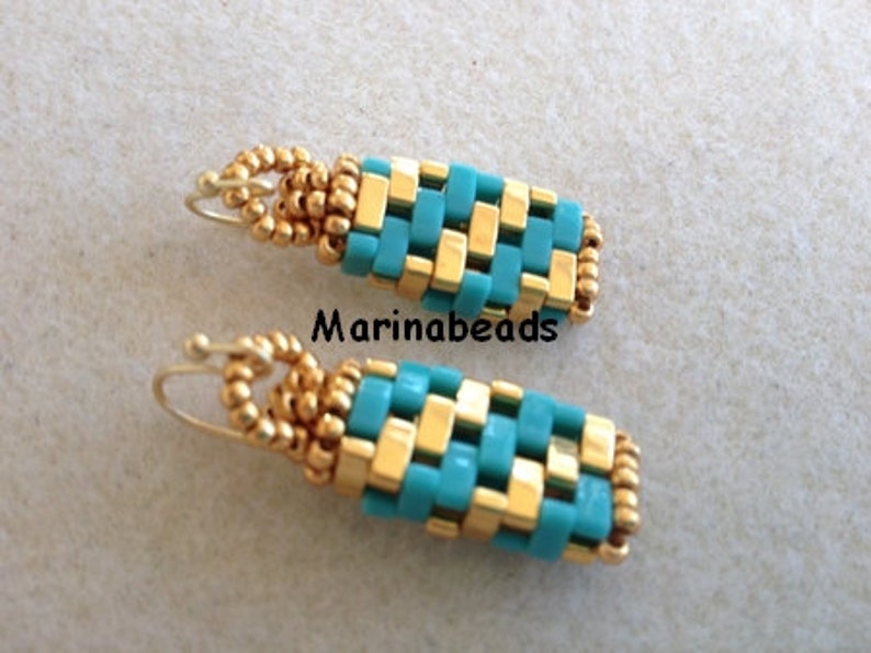 May include: A pair of turquoise and gold beaded earrings with a wire hook closure. The earrings are made with small square beads in a woven pattern.