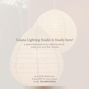May include: Two white spherical paper pendant lamps hang against a light background. Text reads: a new chapter from Talana, Talana Lighting Studio is finally here! a space dedicated to our lighting pieces, made with local Bali artisans, enjoy 30% for your piece Code: TALANAFAM30, talanalightingstudio.etsy.com