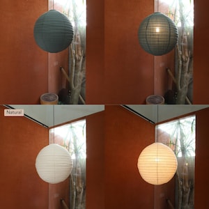 May include: A spherical paper pendant lamp shown in two color variations: Dusty Pine and Natural. Each color is displayed in two states, with the internal light turned off and turned on, revealing the texture of the paper material and the glow.