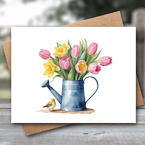Puede incluir: Ilustraci&oacute;n en acuarela de una tarjeta de felicitaci&oacute;n con un ramo de tulipanes rosas y narcisos amarillos en una regadera azul. Un peque&ntilde;o p&aacute;jaro amarillo est&aacute; posado cerca. La tarjeta est&aacute; sobre un sobre marr&oacute;n.