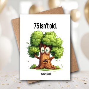 May include: A white greeting card with a brown envelope featuring a cartoon tree with wide eyes and a surprised expression. The text at the top reads 75 isn't old. and the text at the bottom reads If you're a tree. The tree has a brown trunk and green leaves.