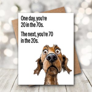 May include: A white ceramic mug with a black handle and the text "But First, Coffee" in a black, bold font. The mug is on a white surface.