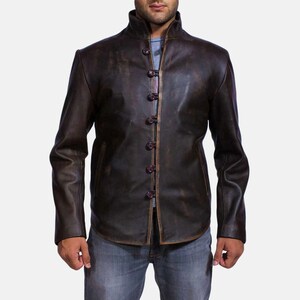Könnte beinhalten: Eine braune Lederjacke mit Stehkragen und Knopfleiste. Die Jacke hat einen Used-Look und ist aus weichem, geschmeidigem Leder gefertigt.