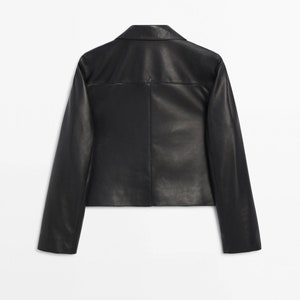 May include: A black leather jacket with a collared neckline and long sleeves.