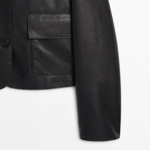 May include: A black leather jacket with a button closure and a patch pocket on the front.