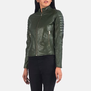 Könnte beinhalten: Eine dunkelgrüne Lederjacke mit Reißverschluss und Steppnähten an den Ärmeln.