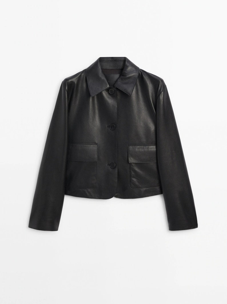 May include: A black leather jacket with a button-up front and two flap pockets.