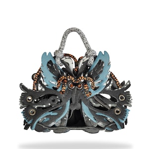 May include: A pair of black and blue sneakers with a unique butterfly-shaped design. The sneakers have a rope handle and orange accents.