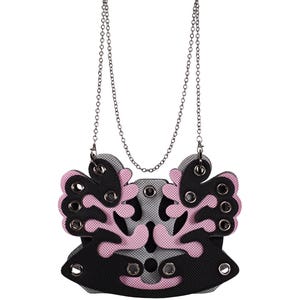 May include: A black and gray pendant necklace with a pink and gray design. The pendant is shaped like a stylized butterfly with multiple holes around the edges. The necklace has a silver chain.