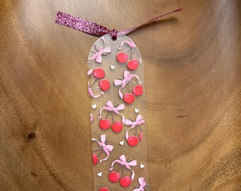 Acrylic bow and cherries bookmark with ribbon.