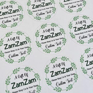 May include: A set of round stickers with a green leafy border. The stickers say "A Gift of ZamZam" with the text "Please Keep Us In Your Duas Custom Text" underneath.