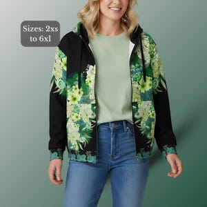 May include: A black zip-up hoodie with a floral pattern in shades of green and white. The hoodie features a hood, a full-length zipper, and a floral design on the front and sleeves. The text "Sizes: 2xs to 6xl" is in the upper left corner.