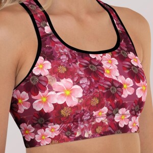 Sujetador deportivo burdeos con diseño floral y estampado botánico. Top de entrenamiento estilo racerback con sujeción de alta compresión. Ideal para gimnasio y fitness.