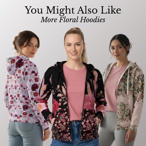 May include: Three women wearing floral hoodies. The hoodies feature various floral patterns in shades of pink, red, and white on a black, light blue, and beige background. The text "You Might Also Like More Floral Hoodies" is at the top.