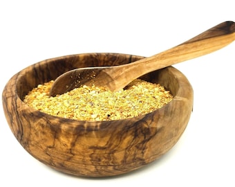 May include: A wooden bowl filled with yellow-brown granules, with a wooden spoon resting inside. The bowl has a natural wood grain pattern and is set against a white background. The spoon is curved and smooth, complementing the bowl's rustic aesthetic.