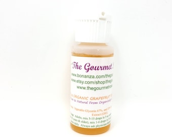 May include: A small, clear bottle with a white cap, filled with a light orange liquid. The label reads "The Gourmet" and lists the product as "Organic Grapefruit Extract." The bottle is on a white background.