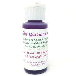 K&ouml;nnte beinhalten: Kleine Flasche lila Fl&uuml;ssigseife mit wei&szlig;em Verschluss. Das Etikett tr&auml;gt die Aufschrift "The Gourmet Rose" und listet Webseitenadressen auf. Die Flasche enth&auml;lt 59 ml fl&uuml;ssige Ultramarin-Naturseife.