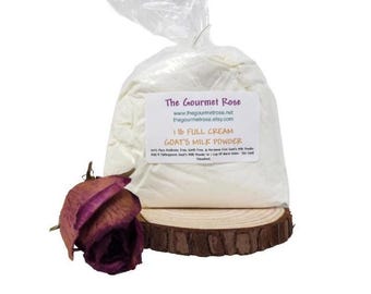Può includere: Un sacchetto di plastica trasparente pieno di polvere bianca, etichettato "1 lb Full Cream Goat's Milk Powder" da The Gourmet Rose. Una rosa rossa scura essiccata poggia su una fetta di legno davanti al sacchetto.